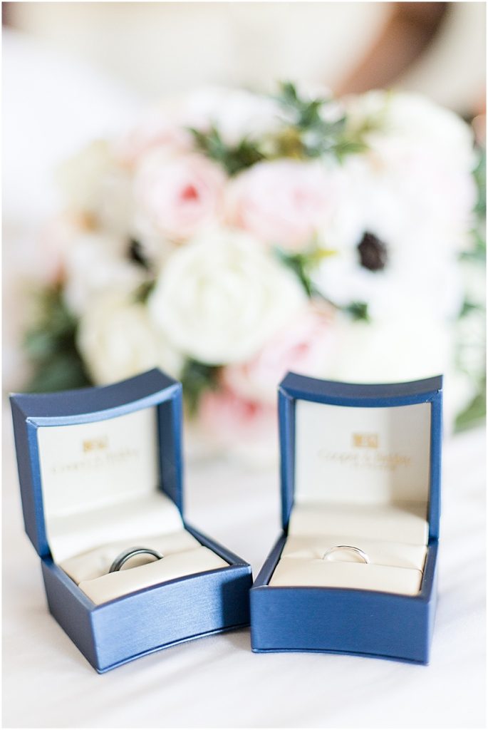 Black and silver rings in their own blue ring boxes 