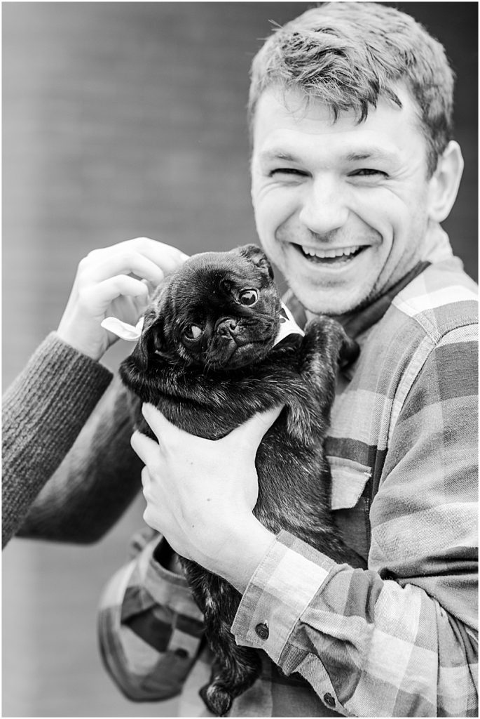 Man holding pug puppy black and white